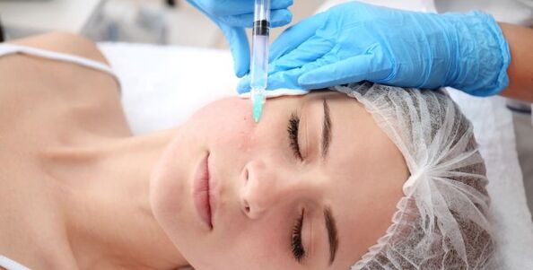 Unha esteticista realiza o rexuvenecemento da pel facial usando plasma